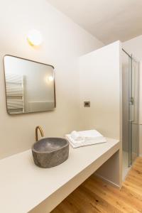 un bagno con un lavandino in pietra e uno specchio di Castello di Ribano Luxury Suites a Montalbano Altre 47 foto