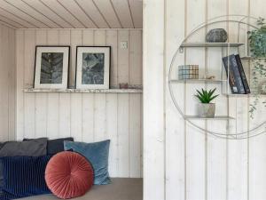 a living room with a couch and a red pillow at Holiday Home Enisa - 800m from the sea by Interhome in Åkirkeby +13 photos