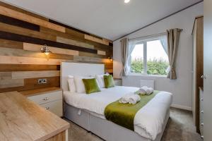 a bedroom with a bed with a wooden accent wall at Clumber Park Lodges in Worksop