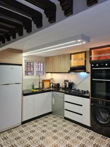 a kitchen with white cabinets and a stove top oven at Riad Dar Fatna in Marrakesh