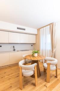 una cucina con tavolo e sedie in legno di Castello di Ribano Luxury Suites a Montalbano