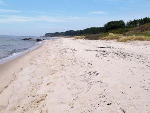 a beach with footprints in the sand and the ocean at Holiday Home Rina - 250m from the sea by Interhome in Hasle
