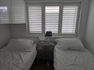 a bedroom with two beds and a table with a mirror at By the Beach Perranporth, Truro, cornwall in Perranporth