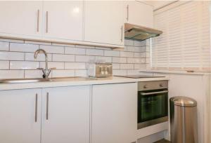a kitchen with white cabinets and a sink at By the Beach Perranporth, Truro, cornwall in Perranporth