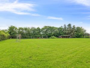 a large grassy field with a playground at Holiday Home Melin - 7km from the sea by Interhome in Højer