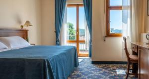 une chambre d'hôtel avec un lit et une fenêtre dans l'établissement Unity Bank Hotel, à Abano Terme