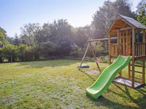 einen Spielplatz mit einer grünen Rutsche im Hof in der Unterkunft Holiday Home Elif - 30km from the sea by Interhome in Toftlund