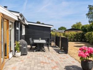 a patio with a table and chairs in a yard at Holiday Home Sari - 250m from the sea by Interhome in Sønderby +15 photos