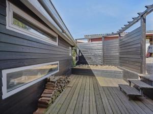 a wooden deck with a bench next to a building at Holiday Home Thrugils - 200m from the sea by Interhome in Haderslev +18 photos