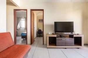 a living room with a flat screen tv on a entertainment center at Casa Vista para Montanhas em Búzios Próxima a Praias e Comércio in Búzios