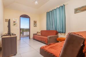 a living room with a bed and a tv and a couch at Casa Vista para Montanhas em Búzios Próxima a Praias e Comércio in Búzios