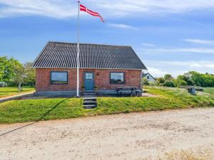a red brick house with a flag in front of it at Holiday Home Swaantje - 150m to the fjord by Interhome in Fur