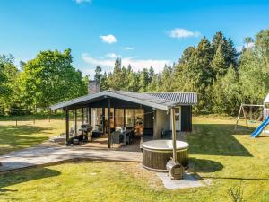 a pavilion with a hot tub and a playground at Holiday Home Eli - 1-5km to the fjord by Interhome in Blåvand