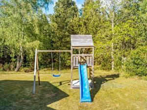 a playground with a swing set in a yard at Holiday Home Eli - 1-5km to the fjord by Interhome in Blåvand
