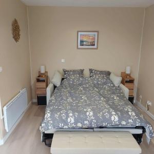 a bedroom with a bed with a blue and white comforter at Le Chti Paradis in Méricourt +47 photos