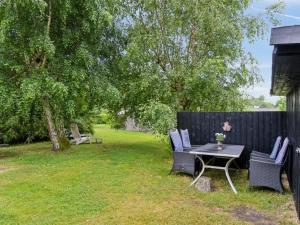 a backyard with a table and chairs and a fence at Holiday Home Imre - 300m from the sea by Interhome in Glesborg