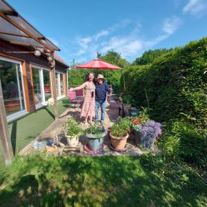 a man and woman standing under an umbrella in a garden at Le Chti Paradis in Méricourt