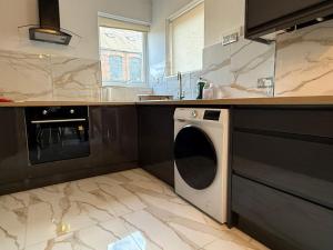 a kitchen with a washer and dryer in it at The Clare Court 6BR Luxury Retreat - Sleeps 14 with Complimentary Access to Billing Aquadrome Holiday Village for Swimming - 2 nights minimum in Kingsthorpe