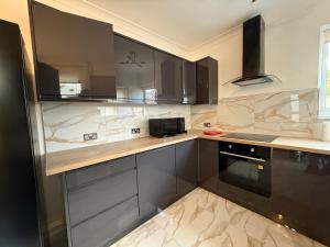 a kitchen with black and white marble counter tops at The Clare Court 6BR Luxury Retreat - Sleeps 14 with Complimentary Access to Billing Aquadrome Holiday Village for Swimming - 2 nights minimum in Kingsthorpe