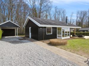 una casa en blanco y negro con garaje en Holiday Home Arnetta - 150m from the sea by Interhome, en Sønderby