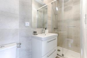 a bathroom with a toilet and a sink and a shower at Mykeypers- Design & Cosy Apartment 2P - Malakoff 25 in Malakoff