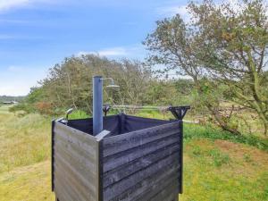 a wooden container with a fire hydrant in a field at Holiday Home Alma - 500m from the sea by Interhome in Løkken