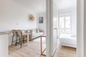 a white living room with a couch and a table at Mykeypers- Design & Cosy Apartment 2P - Malakoff 25 in Malakoff