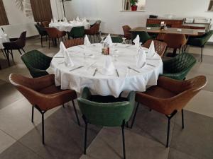 a dining room with a white table and chairs at Motel Citadela 023 in Zrenjanin +25 photos