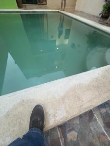 a person standing on the edge of a swimming pool at Departamentos misavi in Pisté