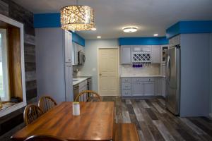 a kitchen with a wooden table and a refrigerator at Cozy Meets Luxury in Tylersville