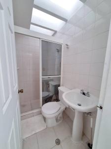 ein weißes Badezimmer mit Toilette und Waschbecken in der Unterkunft Valle Alegre in El Valle del Espíritu Santo + 5 Fotos