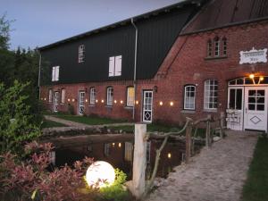 un granero con un reflejo en el agua frente a él en Pottkiekerhus, en Luhnstedt