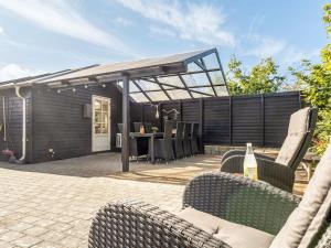 a patio with chairs and a table and a building at Holiday Home Engelbertine - 210m to the fjord by Interhome in Struer +22 photos