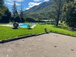 une cour avec une piscine dans l'herbe dans l'établissement Maison de la tuilière hautes alpes piscine et boulodrome 12 personnes, à Saléon
