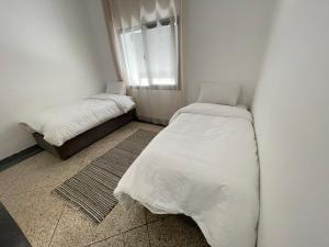 a small bedroom with two beds and a window at Apartment amina in Azrou