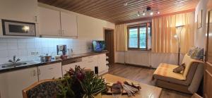 Una cocina con un fregadero y una mesa en una habitación. en Ferienwohnung Wilder Kaiser Nähe Bergdoktor Drehorte IDT098 by FeWo-Plan, en Itter