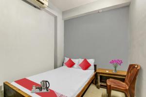 a small bedroom with a bed and a table at Hotel O Ganpati in Patna