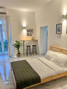 1 dormitorio con cama y mesa con taburetes en Dimora San Mario, en Portici
