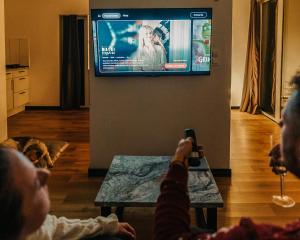 a group of people sitting in a living room watching a television at Moje Miejsce Polanica-Zdrój in Polanica-Zdrój