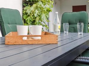 un plateau en bois sur une table avec deux verres et une bouteille dans l'établissement Holiday Home Hakon - 550m from the sea by Interhome, à Gedser