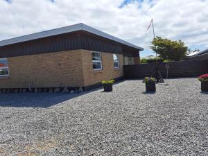 a brick building with potted plants in front of it at Holiday Home Falk - 900m from the sea by Interhome in Skagen