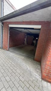 a garage with a brick wall and an open door at In De Wulf in Ypres