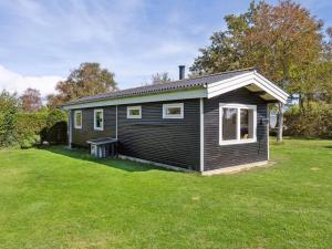 a small house in a yard with a green lawn at Holiday Home Imma - from the sea by Interhome in Karrebæksminde