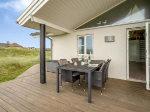 a patio with a table and chairs on a deck at Holiday Home Elfi - 700m from the sea by Interhome in Ringkøbing
