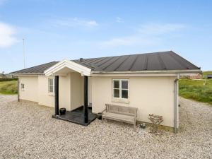 a small white house with a black roof at Holiday Home Elfi - 700m from the sea by Interhome in Ringkøbing