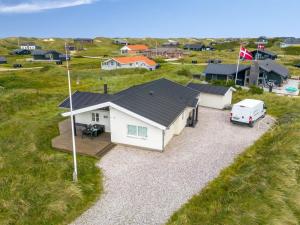 an aerial view of a white house with a van parked in front at Holiday Home Elfi - 700m from the sea by Interhome in Ringkøbing