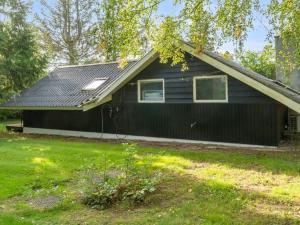 a black house with a pitched roof at Holiday Home Ninni - 3-2km from the sea by Interhome in Eskebjerg
