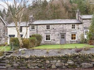 an old stone house with a stone wall at Cosy, characterful cottage in Betws-y-Coed in Betws-y-coed