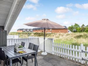 a patio with a table and an umbrella at Apartment Rohan - 2-2km from the sea by Interhome in Havneby