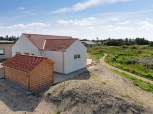a small white house with a red roof on a dirt road at Holiday Home Yakari - 1km from the sea by Interhome in Torsted